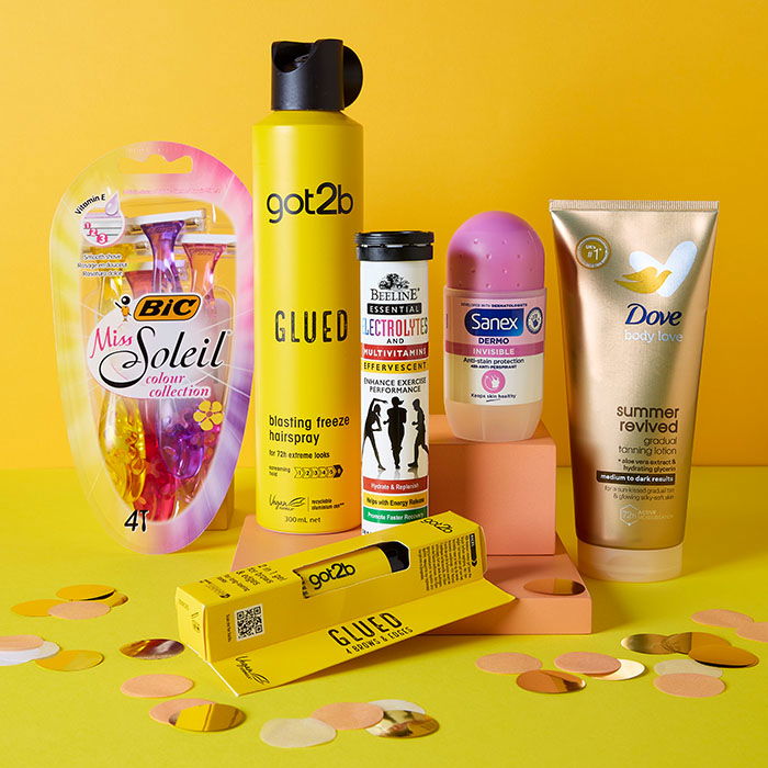 Multicoloured Miss Soleil razers, Got2b Glued hairspray, Got2b Glued 4 Brows & Edges 2 in 1 gel, Beeline Electrolytes and multivitamins orange flavour tablets, Sanex Dermo Invisible Antiperspirant deodorant Roll-On, Dove Summer Revived Gradual Tanning Lotion Medium to Dark on a yellow background and lime green ground with rose gold confetti around the base of the products.
