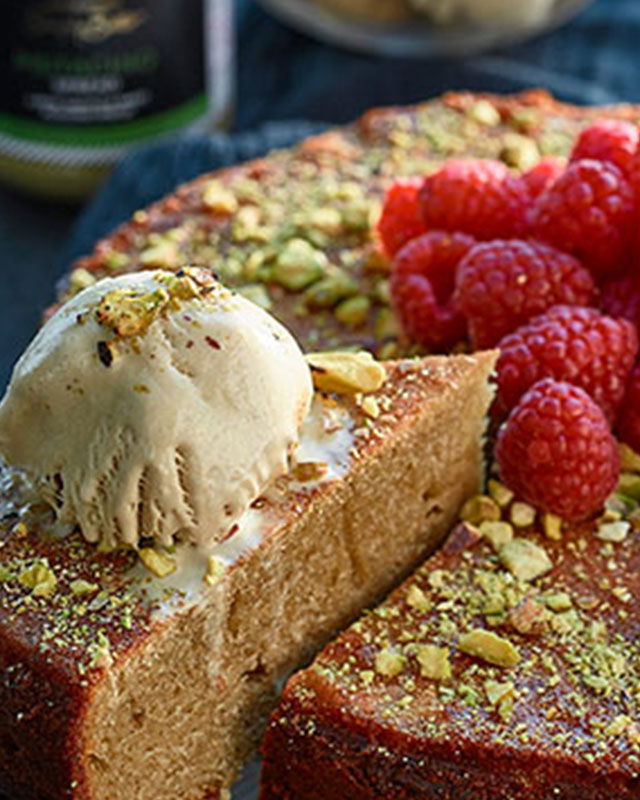 Warm pistachio cake served with a scoop of vanilla gelato and a sprinkle of chopped nuts