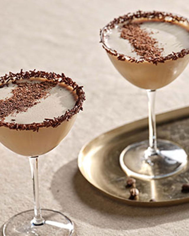 Elegant Bailey’s Flat White Martini in a coupe glass, topped with a creamy froth and chocolate flakes