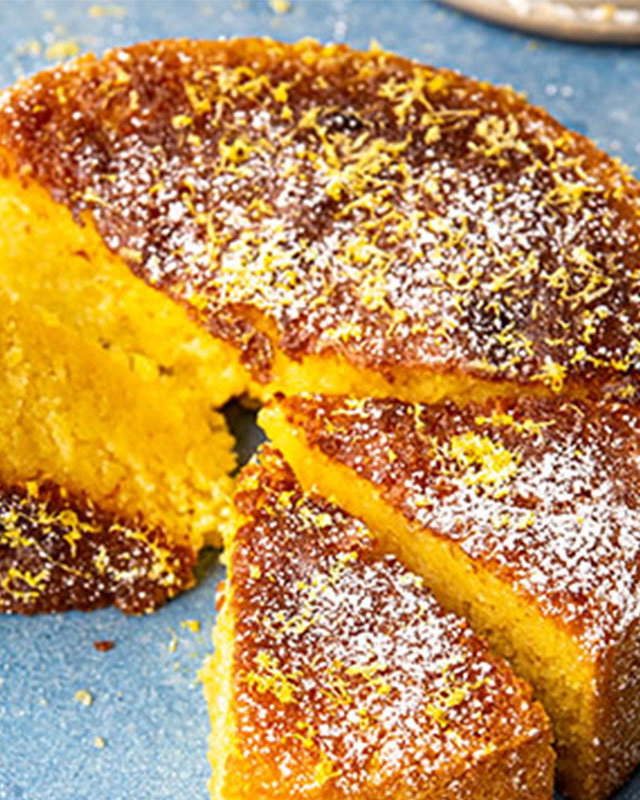 Limoncello cake topped with citrus glaze and lemon slices on a serving plate