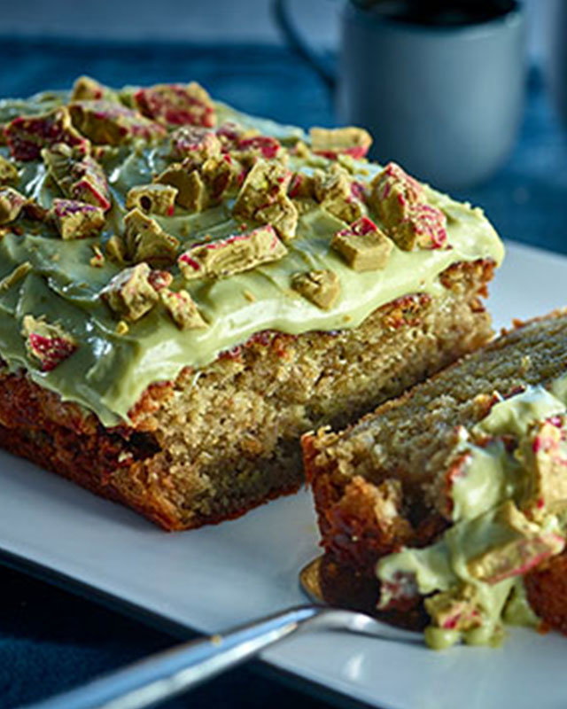 Moist banana bread with pistachios and a golden crust, sliced for serving