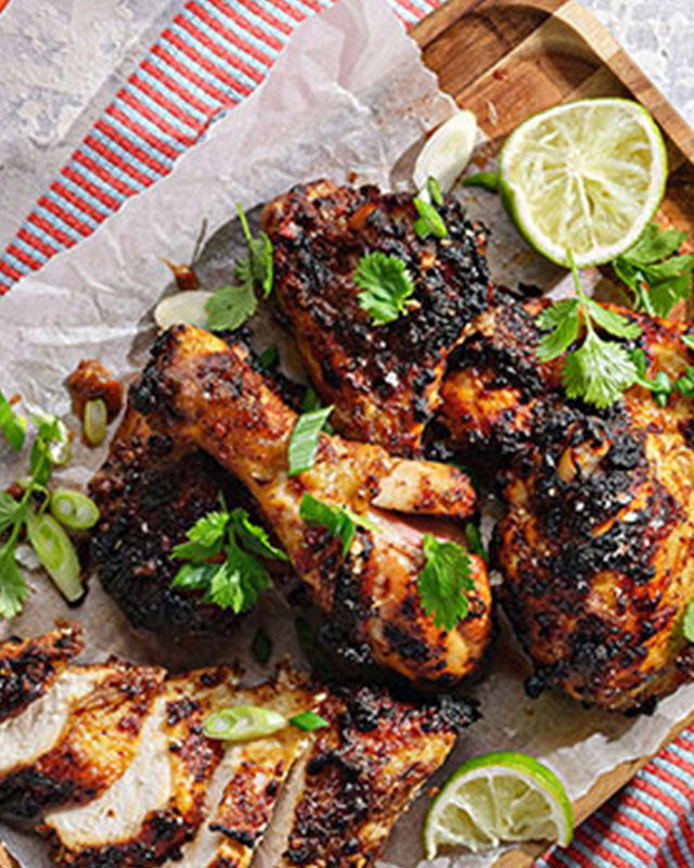 BBQ jerk chicken thighs served with fresh mango salsa on a plate