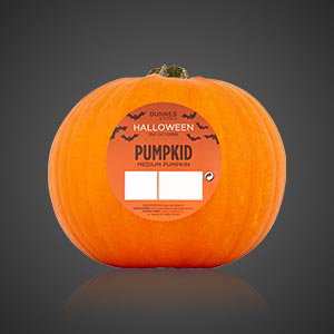 Whole pumpkin with a Halloween product label on the front, isolated against a dark background