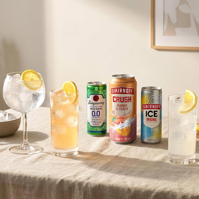 A selection of refreshing beverages: a gin and tonic, pre-mixed cans, and iced drinks, all garnished with lemon slices.