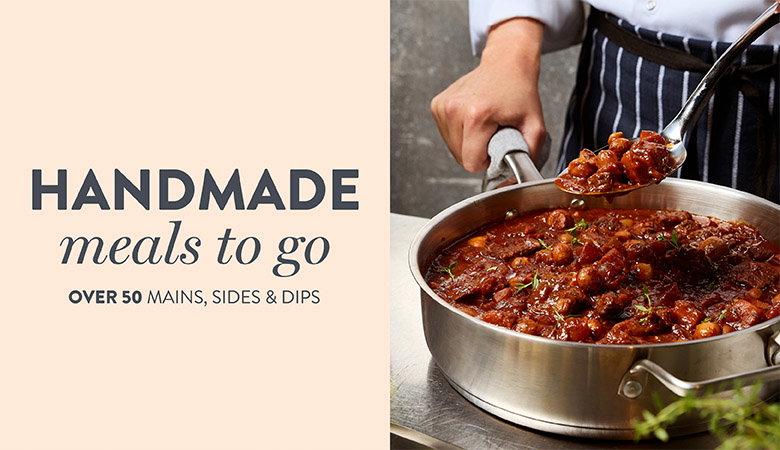 Hand holding a spoonful of hearty stew over a stainless steel pan, beside text promoting handmade meals to go with 50+ options.