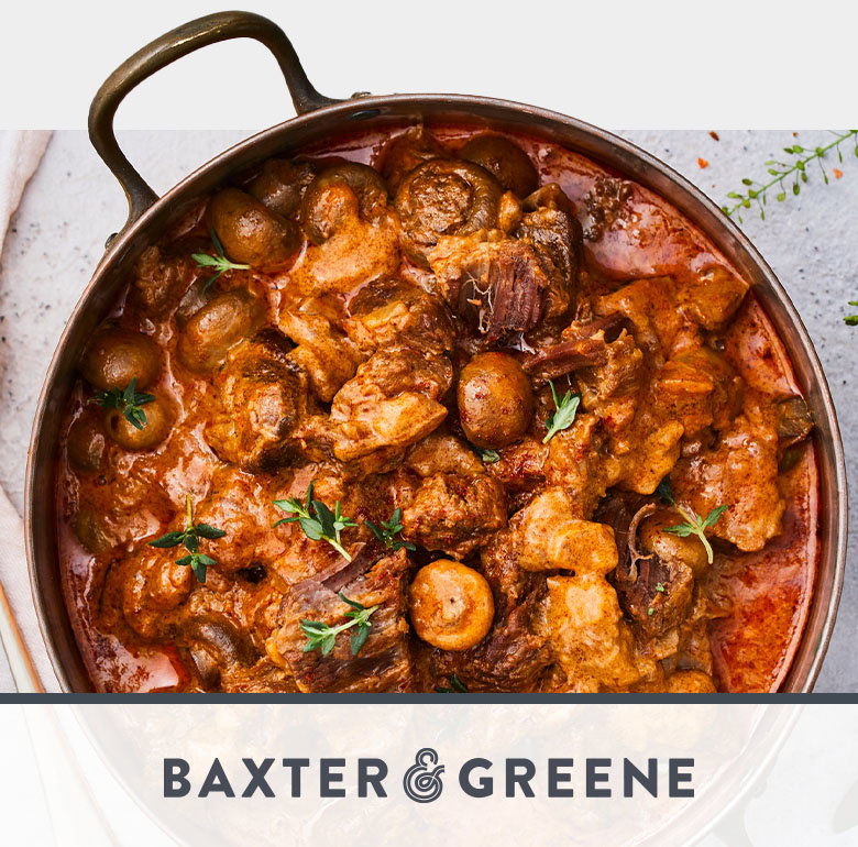 A copper pot filled with a rich beef stew containing chunks of meat, mushrooms, and herbs in a dark red sauce, accompanied by the Baxter & Greene Market Deli logo