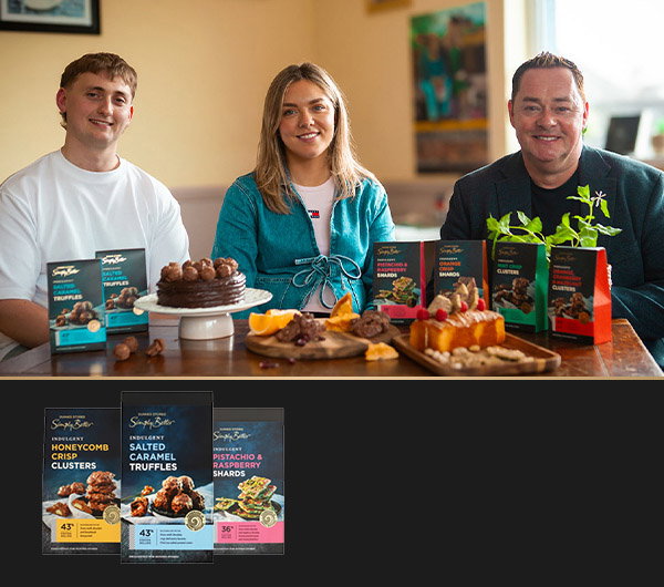 Nevan Maguire visits Bon Chocolatier's HQ and sits at a table, surrounded by various desserts and chocolates, featuring colourful packaging of gourmet treats.
