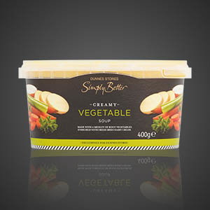 Tub of Dunnes Stores Simply Better creamy vegetable soup, 400g, with images of assorted vegetables on the packaging, on a dark background