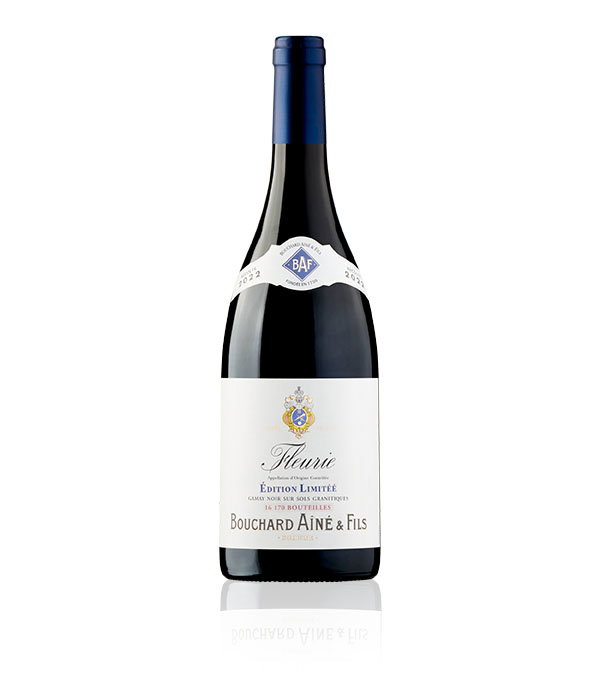 A bottle of Bouchard A&icirc;n&eacute; & Fils Fleurie wine with a navy foil cap. The label is white with a crest and elegant typography, conveying luxury.