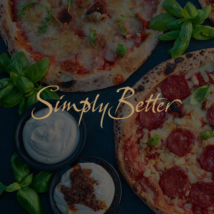 Two pizzas, one with cheese and herbs, the other with pepperoni, are surrounded by fresh basil and two bowls of creamy dips. Text reads Simply Better.