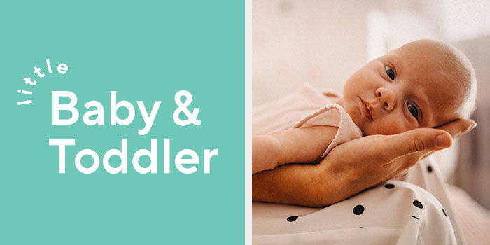 Little Baby & Toddler logo on turquoise background. A newborn baby looking towards us while lying on a hand on top of a pair of knees