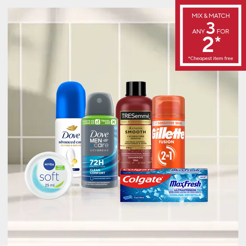 Assorted personal care products including deodorant, shampoo, shaving gel, and toothpaste on a white tiled bathroom surface. Red sign: "Mix & Match Any 3 for 2".