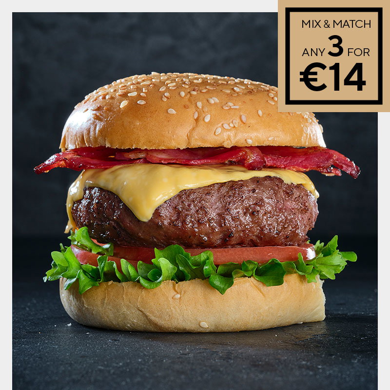 A juicy cheeseburger with crispy bacon, lettuce, and tomato on a sesame seed bun against a dark background. A red label reads "Mix & Match any 3 for €14."